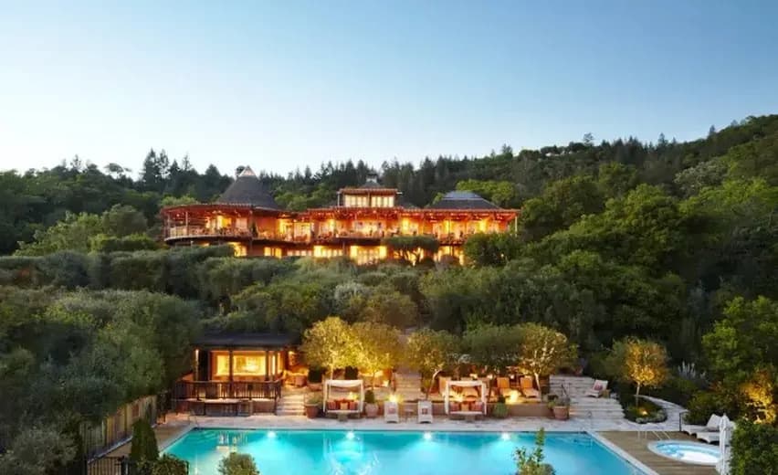 Hillside resort with a pool, lit up at dusk